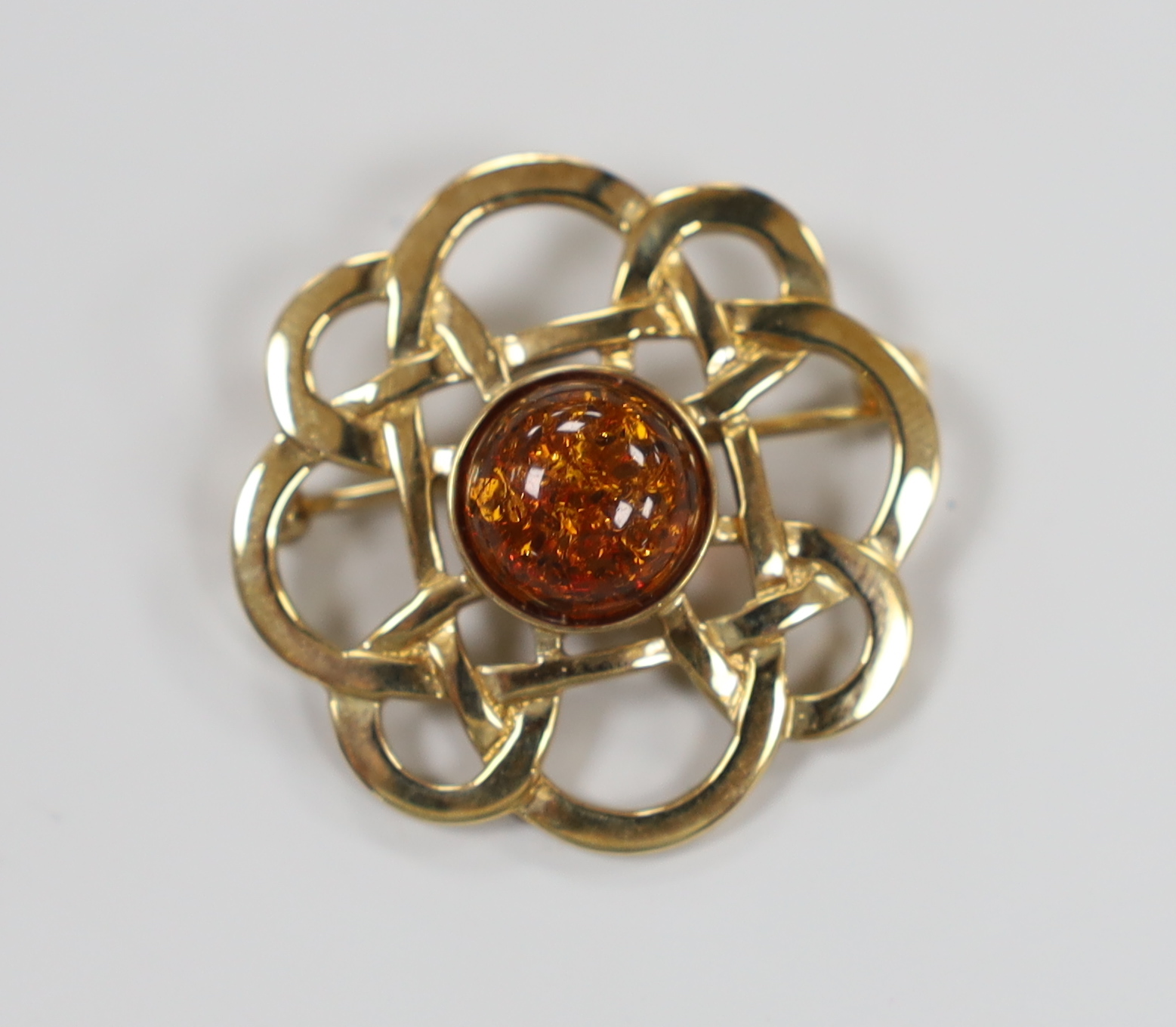 A yellow metal and amber set Celtic design brooch, 29mm, gross weight 5.3 grams.